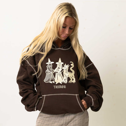 Woman wearing a brown hoodie with a graphic design and text on a white background