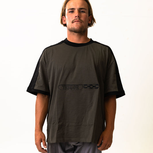 Man wearing a dark gray t-shirt with a logo on a white background