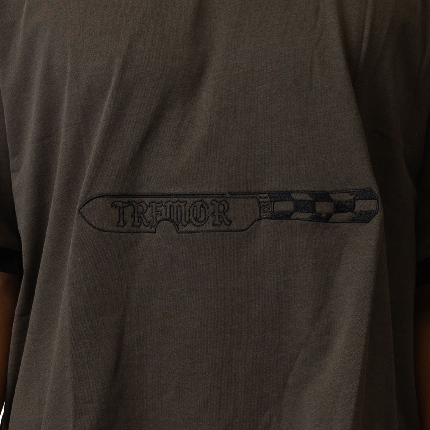 Dark gray t-shirt with 'Tremor' logo on the chest