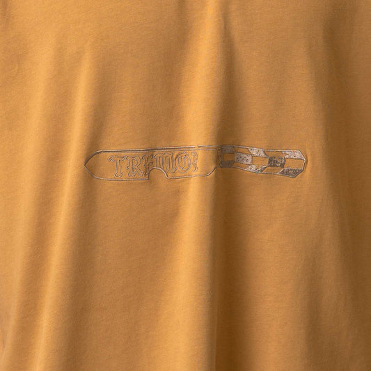 Close-up of a brown fabric with a metallic logo or text.